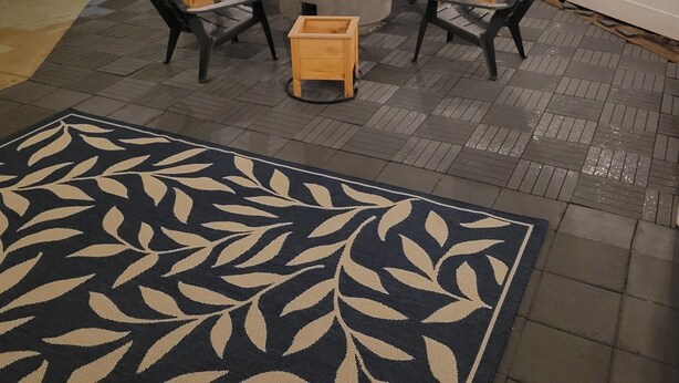 Un patio con una chimenea, cuatro sillas y una mesa.