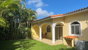 A yellow building with a tiled roof, white columns, and a covered patio area. - Sosua Ocean Village, villa 19a (Sosúa)