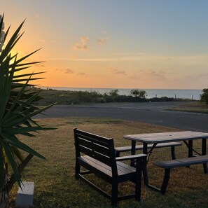 Ein Picknickbereich mit Bank und Tisch mit Blick auf einen Strand.