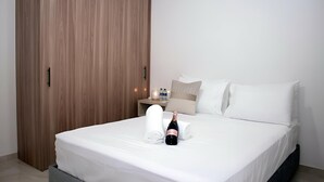 A hotel room with a bed, a wooden wardrobe, a nightstand with a bottle and glasses, and a towel. - Apartment in Cartagena (Cartagena de Indias)