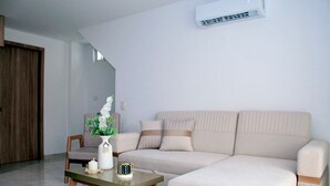 A living room with a beige sofa, a wooden coffee table, and a white vase with flowers. - Apartment in Cartagena (Cartagena de Indias)