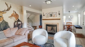 A modern living room with a fireplace, a staircase, and a dining area. - Chimney Corner- Keswick Home Close to Vineyards (Keswick)