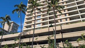 A high-rise building with multiple balconies and palm trees in the foreground. - Newly renovated, secure, 2-bedroom apartment in beautiful Waikiki with AC (Honolulu)