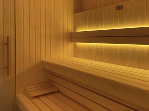 Una sauna con bancos de madera y suelo inclinado.