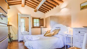 A bedroom with a bed, a chair, a nightstand, a dresser, a mirror, and a window. - Rifugio di Igor by Interhome (Montecatini Terme)