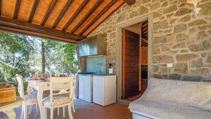 A cozy outdoor dining area with a stone wall, wooden ceiling, and a sofa. - Rifugio di Igor by Interhome (Montecatini Terme)