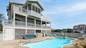 Un bâtiment à deux étages doté d’un balcon, d’une piscine et d’un espace extérieur aménagé pour s’asseoir.