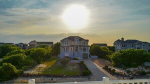 Une grande maison à deux étages, dotée d’un porche avant imposant et d’une pelouse bien entretenue.