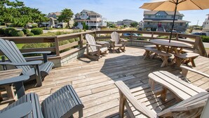 A wooden deck with Adirondack chairs and a table, surrounded by a wooden railing. - Resort Amenities, Community Pools, Hot Tub-645, Cohasset II (Corolla)
