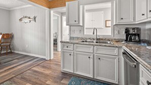A kitchen with white cabinetry, a granite countertop, a coffee maker, and a wooden ceiling. - Classic 4BR Cherry Grove home w/ elevator, full kitchen & short walk to beach (North Myrtle Beach)
