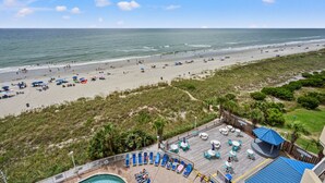Un complexe hôtelier en bord de mer doté d’une piscine, de parasols et offrant une vue sur l’océan.
