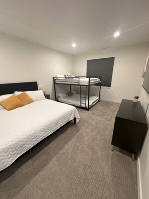A bedroom with a bunk bed, a single bed, a desk, and a grey wall. - Sleeps 30 • Hot Tub • Sauna • Pool • Walk to Bear Lake Marina (Garden City)