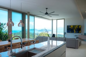 Een moderne keuken met een groot eiland, een eethoek en uitzicht op de bergen.