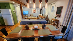 A cozy living room with a sofa, a coffee table, and a fireplace. There is a dining table with placemats and a decorative centerpiece. - L'Ancestrale (view, spa, arcade) (La Malbaie)