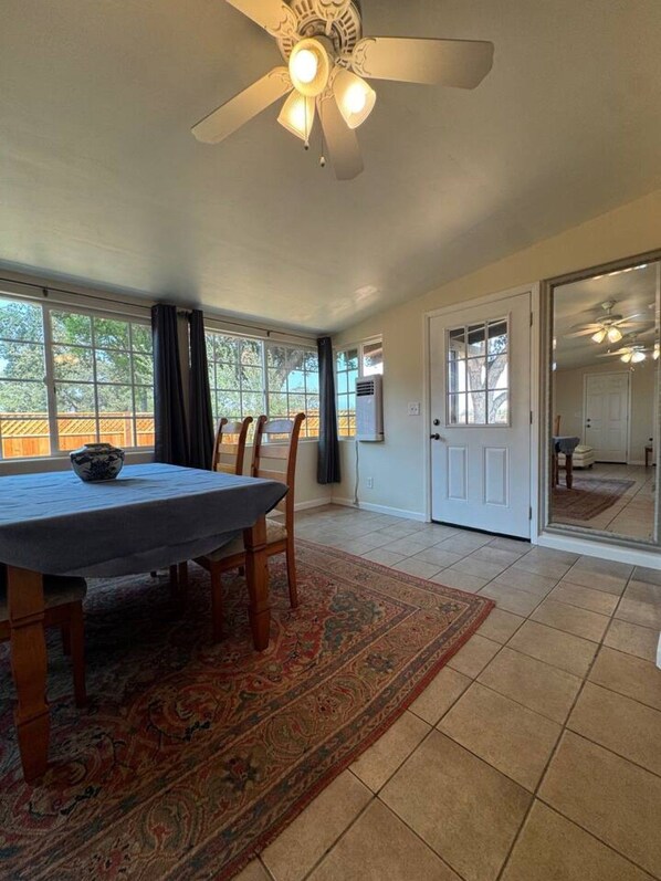 A dining area with a table, chairs, and a ceiling fan.