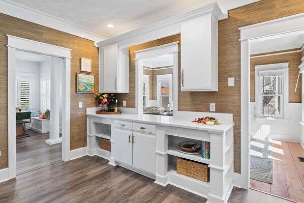 A spacious kitchen with white cabinetry, wooden accents, and built-in shelving.