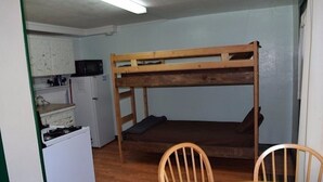 Ein Stockbett mit Küchenzeile, einschließlich Kühlschrank, Mikrowelle und Herd.