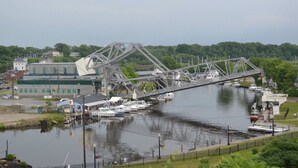 Un pont enjambant une rivière, avec des bateaux amarrés à proximité.
