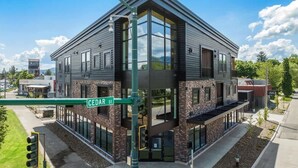 A modern building with large windows and a stone facade, located at Cedar Street.