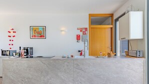 A modern kitchen with a marble countertop, a coffee machine, a toaster, and a sink. - Suites Sunny Hill by Interhome (Moncarapacho/Olhão)