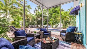 An outdoor patio with wicker furniture, a pool, and lush greenery. - Luna Nueva: Private Pool, New Renovation, Sleeps 8 (Sarasota)