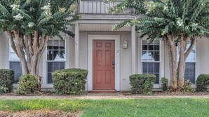 A two-story house with a brown door, two windows, and a small porch. - Lampkin Stay, Cotton District, Walk to MSU (Starkville)