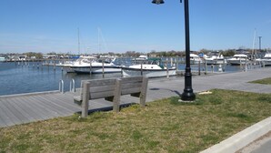 A marina with boats docked, a wooden walkway, and a bench. - Comfort Suite in charming Bay Shore (Bay Shore)