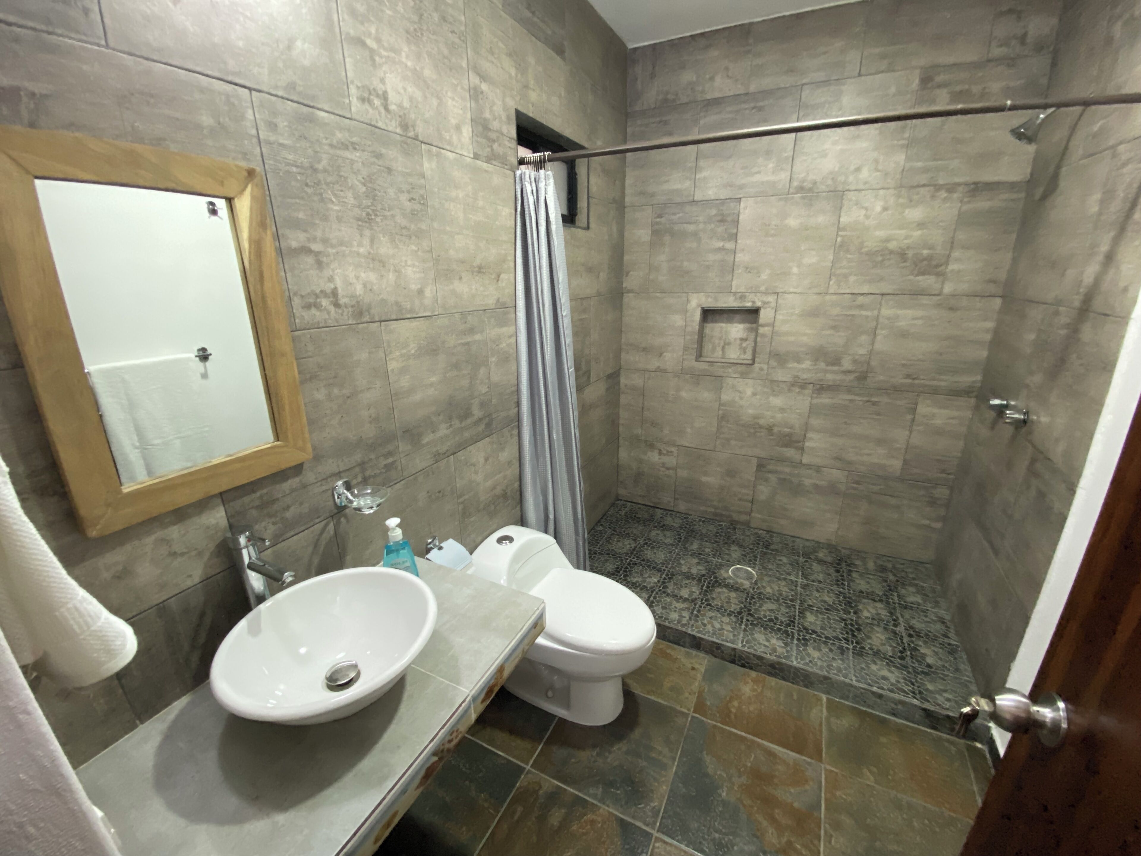 A bathroom with a sink, toilet, and shower.