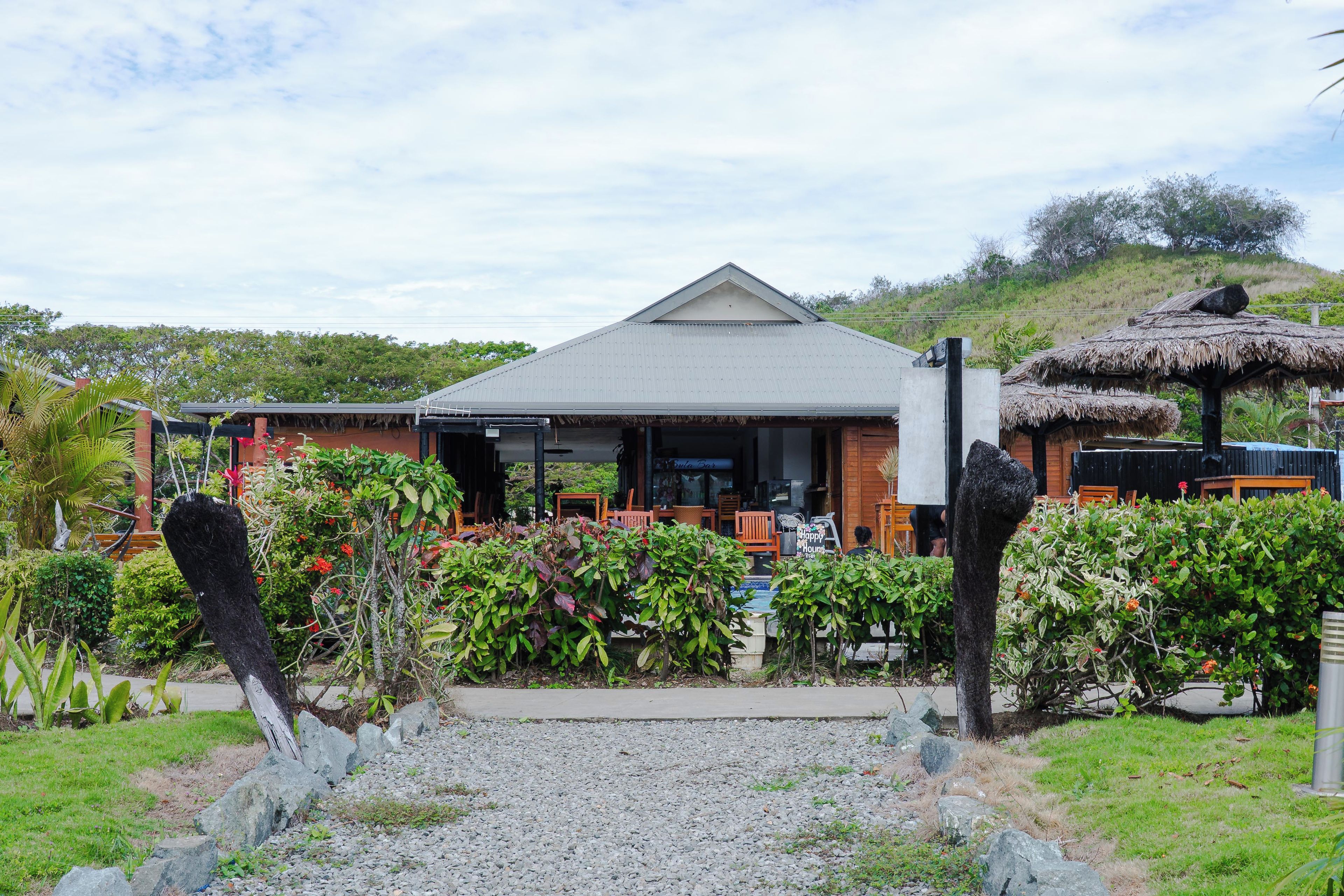 A building with a grey roof and a covered outdoor seating area.