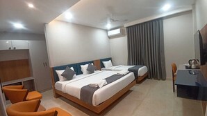 Een hotelkamer met een groot bed, twee nachtkastjes, een bureau met een stoel, en een televisie.