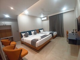 A hotel room with a large bed, two bedside tables, a desk with a chair, and a TV.