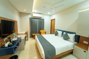 Une chambre d’hôtel équipée d’un lit, d’un bureau, d’une chaise et d’un téléviseur.