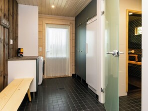 Un couloir étroit avec un banc, une porte et une fenêtre.