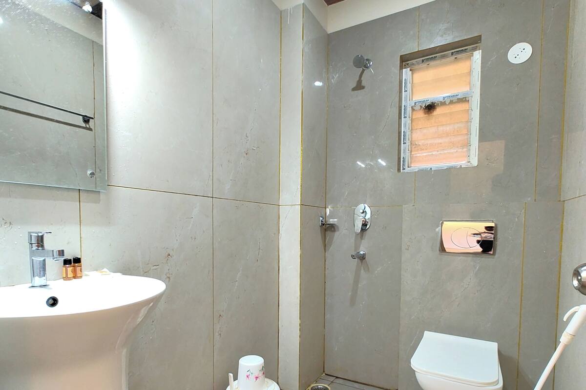 Une salle de bain avec un lavabo, des toilettes et une douche.