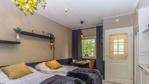 Une chambre d’hôtel avec deux lits, une petite table et une fenêtre.