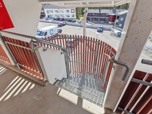 A metal staircase with a metal handrail leading to a covered outdoor area.