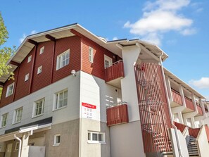 A multi-story building with a red and white facade, balconies, and a sign indicating 'LeviStar III' with room numbers.
