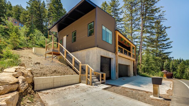 A modern two-story house with a wooden staircase, a garage, and a driveway.