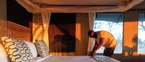 A room with a bed, a window, and curtains.