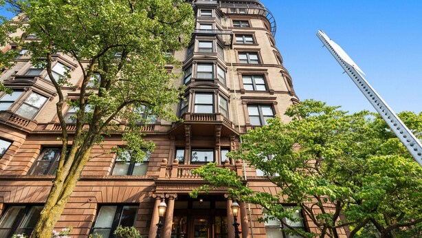 A multi-story building with a classic architectural style, featuring a prominent entrance with columns and a balcony.