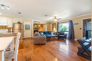 A spacious living area with a dining table, sofa, and TV. - Over The Hill By The Bayou, Pool, Family Friendly (Pensacola)