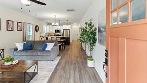A modern living room with a grey sofa, a coffee table, and a ceiling fan. - Heart of Cedartown | 0.3 miles from the Silver Comet Trail (Cedartown)