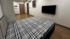 A bedroom with a bed, a flat-screen TV, and an air conditioning unit on the wall. - Oanh Luxstay (Bac Hong Linh)