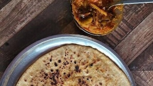 A round metal plate with a flatbread on a wooden surface. - Kedar Hill Resort  (Ukhimath)