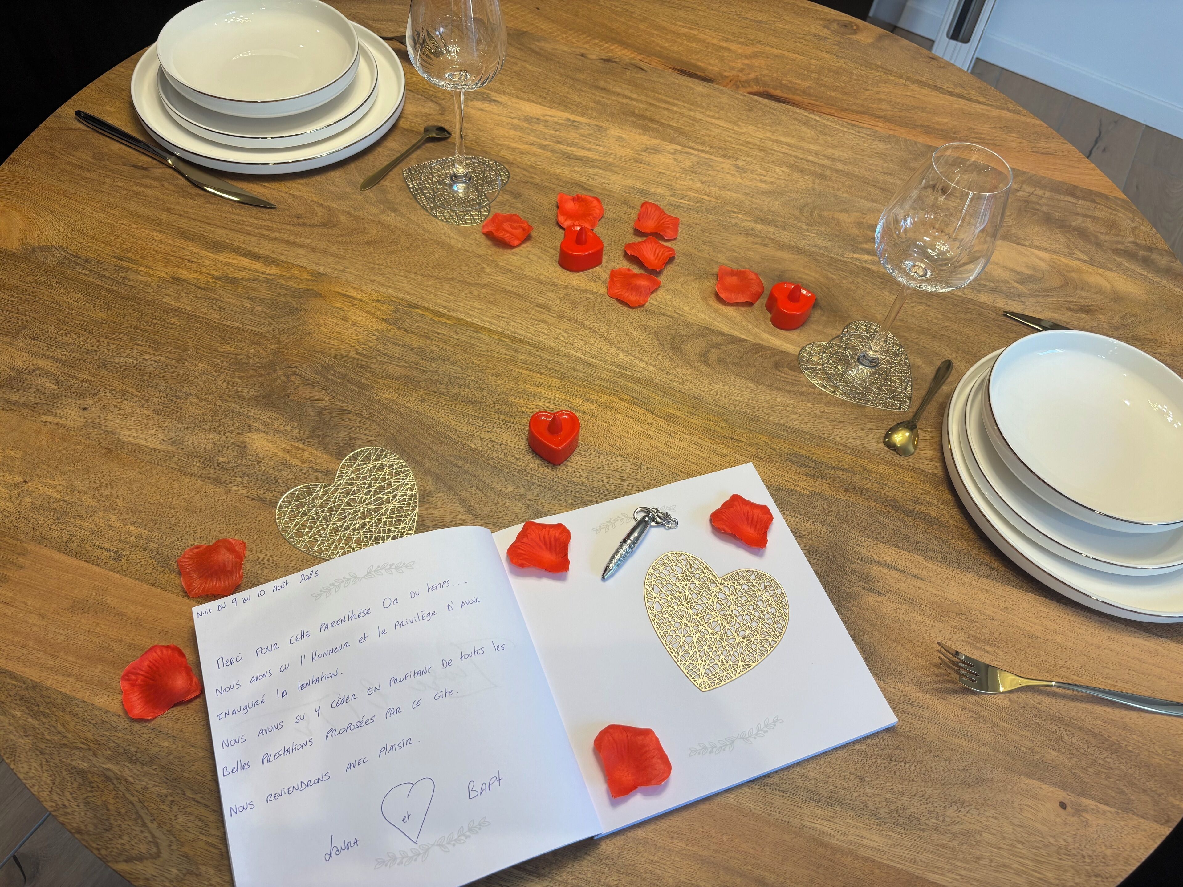 Een gedekte tafel met borden, glazen, bestek en een kaartje met een hartmotief.