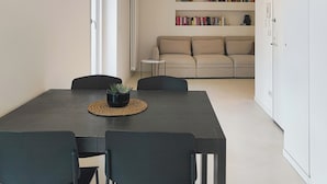 A modern living room with a dining area, a sofa set, and a bookshelf. - Piano 7 | Bright penthouse with terrace (Torino)