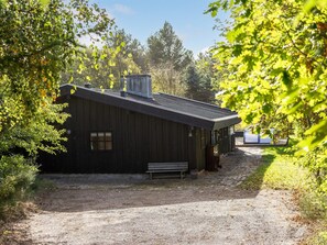 A rustic cabin with a wooden exterior, a chimney, and a bench outside. - "Arsi" - 1.8km from the sea by Interhome (Blokhus)