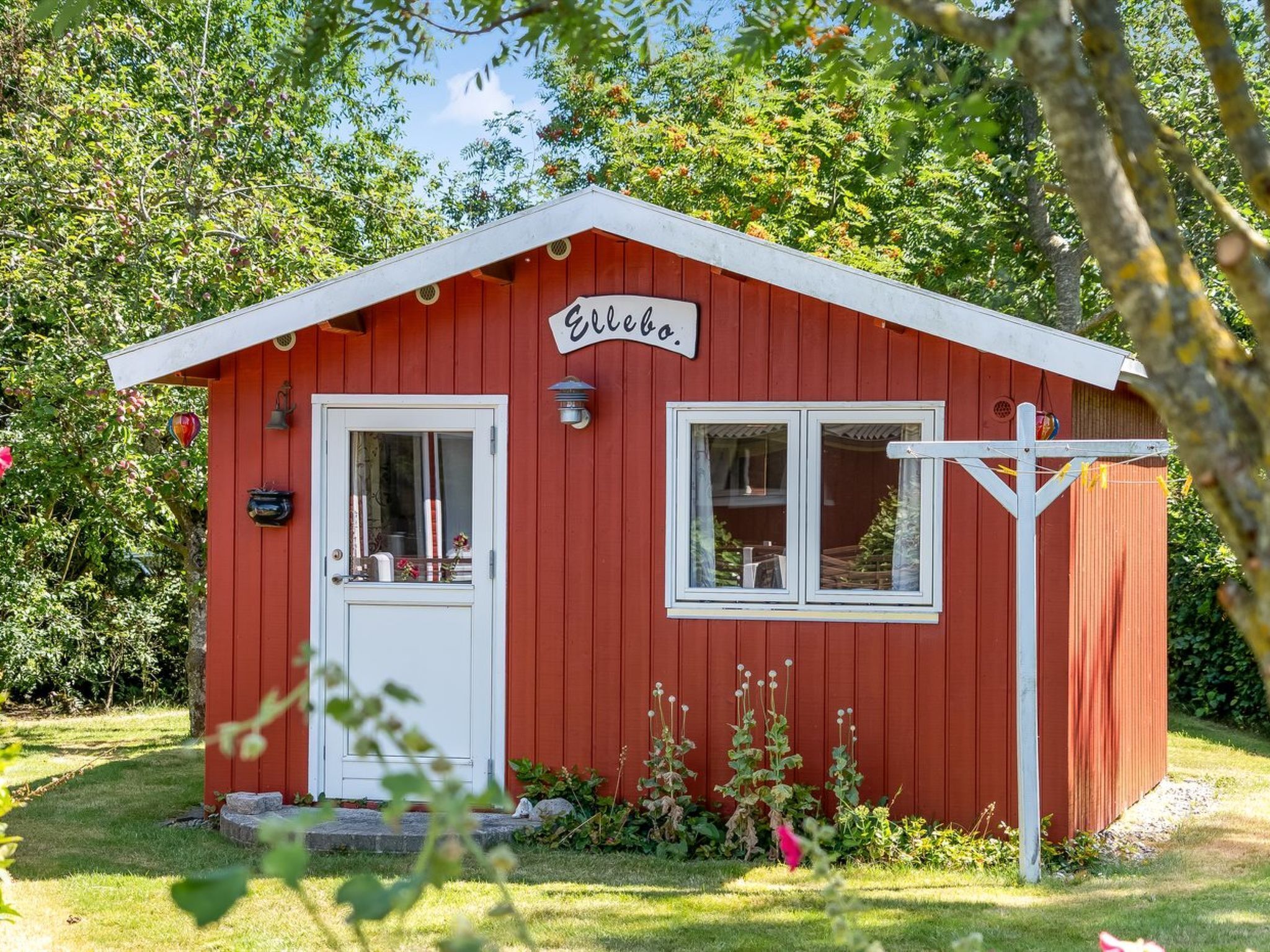 A small red wooden building with a white door and windows, labeled "Elbo."