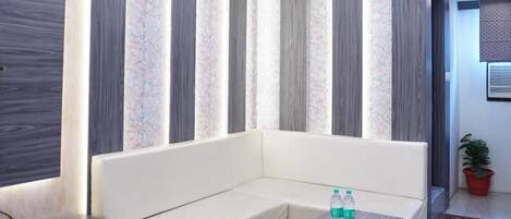 Una sala de estar moderna con sofá, mesa de centro y ventilador de techo.