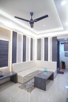 A modern living room with a sofa, coffee table, and ceiling fan.